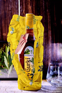 Gurktaler My Gurki mit einem Geschenkschild und eingewickelt in Geschenkpapier. 0,7l 27% vol.