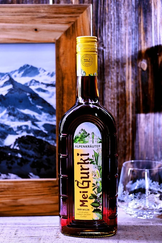 Gurktaler Mei Gurki mit einem Geschenkschild und eingewickelt in Geschenkpapier. 0,7l 27% vol.