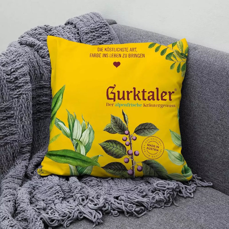 Gurktaler Outdoor Kissen. Von der einen Seite gelb und von der anderen Seite blau